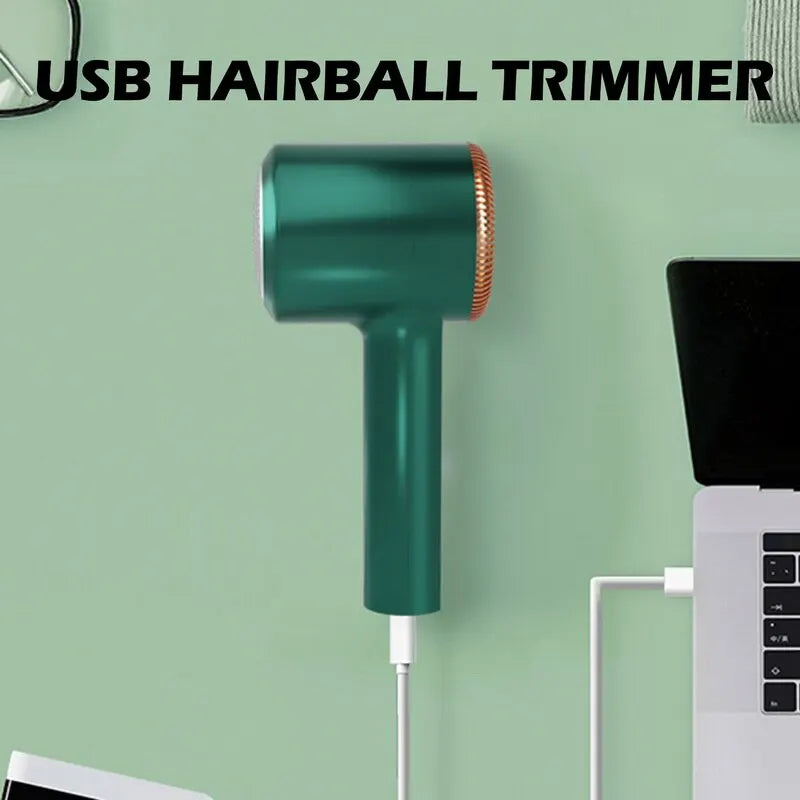 Green USB lint remover mounted on wall beside a laptop, USB hairball trimmer