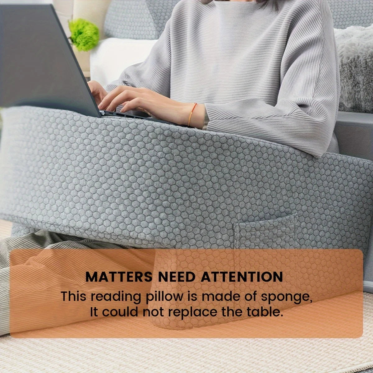 Person using a laptop on a gray honeycomb-patterned reading pillow with text overlay.