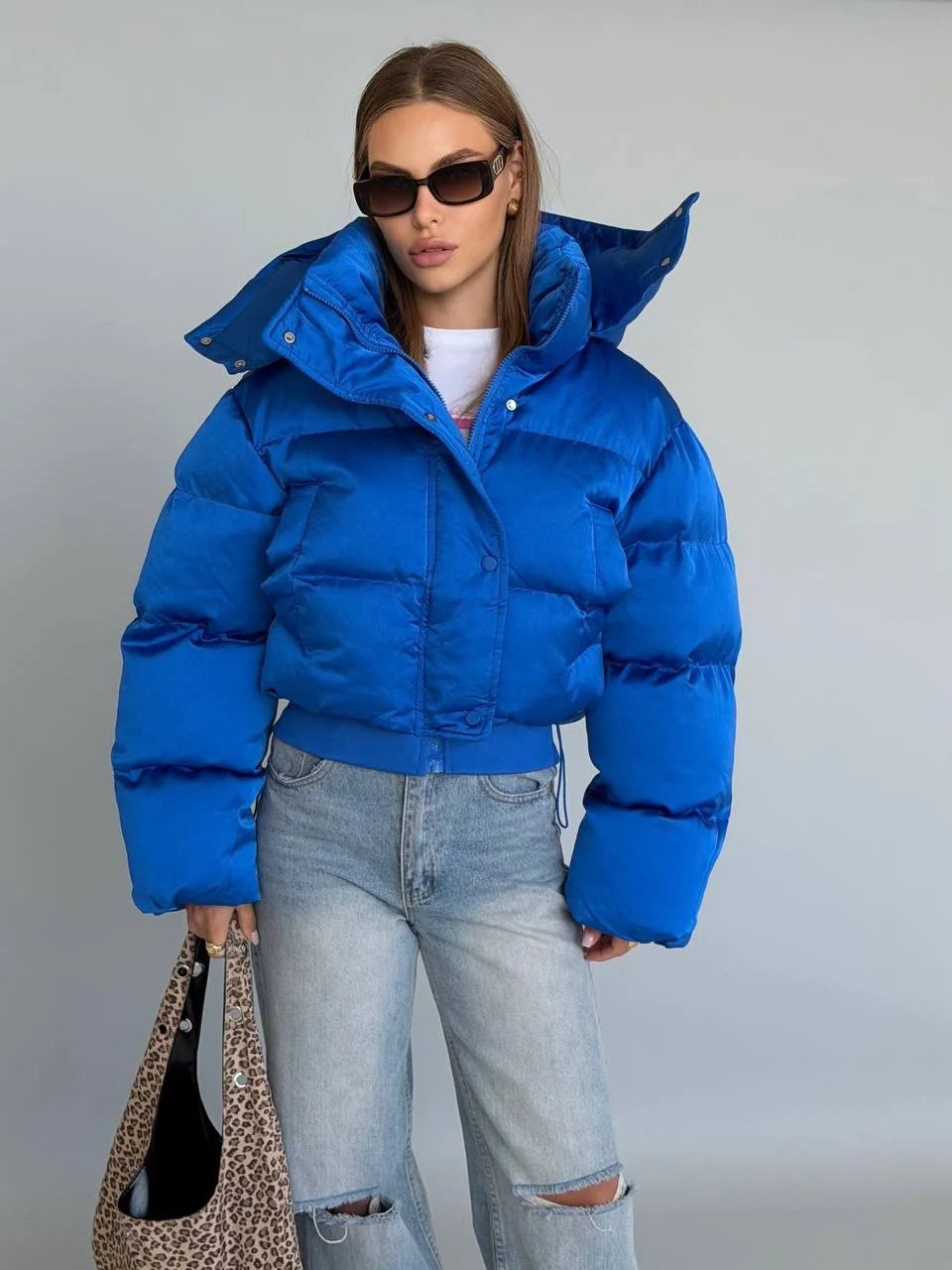 Blue cropped bubble puffer jacket with cinched waist, front view
