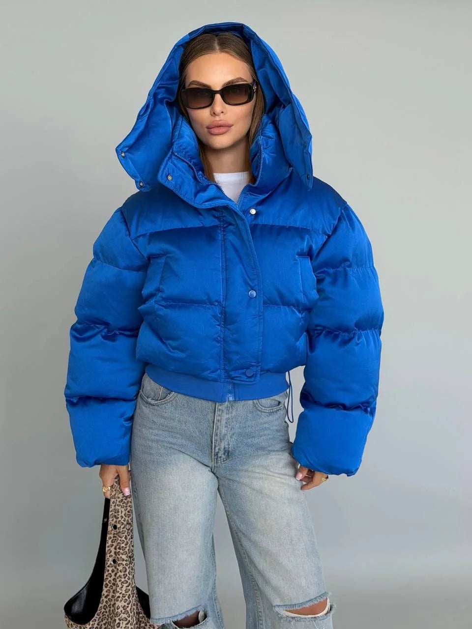Woman wearing the Blue hooded cropped bubble puffer jacket with hood up